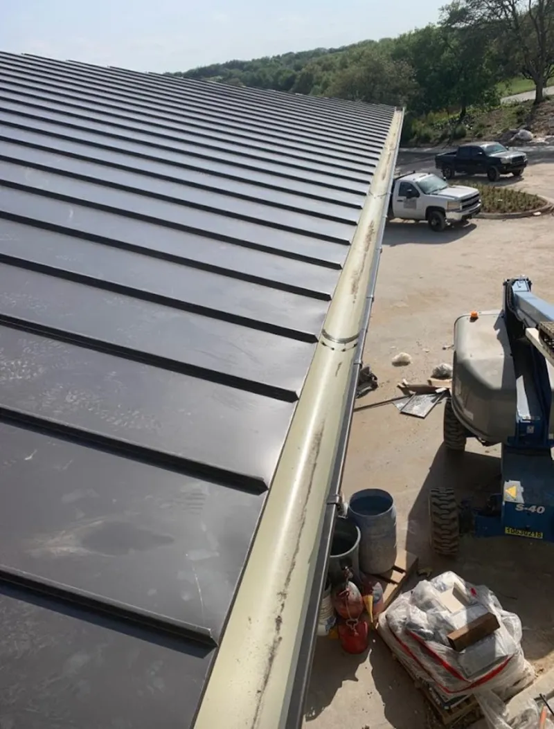 Standing seam panel and gutter detail on a metal roofing jobsite in Amherst
